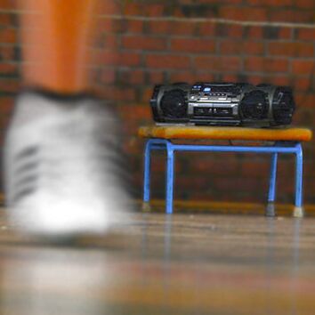 tanzender weißer Schuh im Vordergrund und Musikbox im Hintergrund