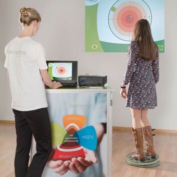 Frau steht auf Challenge Disc und führt eine Messung durch, andere Frau analysiert